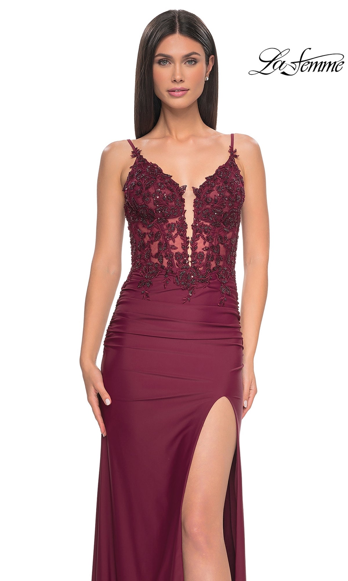 A woman models the La Femme Plunging V-Neck Long Prom Dress 32132, showcasing a sleeveless burgundy lace corset bodice, deep V-neckline, and high slit. The